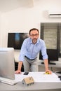 Mature male architect working on laptop on building project drawing sketch in office studio workspace Royalty Free Stock Photo