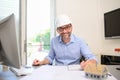 Mature male architect working on laptop on building project drawing sketch in office studio workspace Royalty Free Stock Photo