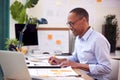 Mature Male Architect Working In Office At Desk Studying Plans For New Building Royalty Free Stock Photo