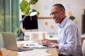 Mature Male Architect Working In Office With Model On Desk Studying Plans For New Building Royalty Free Stock Photo