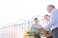 Mature male biochemist discussing with female botanists against clear sky