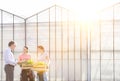 Mature male biochemist discussing with female coworkers against greenhouse Royalty Free Stock Photo