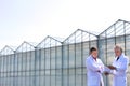 Low angle view of mature male biochemists discussing while standing against clear blue sky