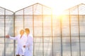 Mature male biochemists discussing while standing against clear blue sky