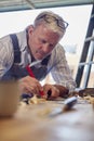 Mature Male Carpenter In Garage Workshop Marking Wood With Pencil And Steel Ruler Royalty Free Stock Photo