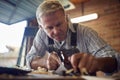 Mature Male Carpenter In Garage Workshop Planing Piece Of Wood Royalty Free Stock Photo