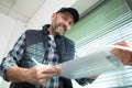 mature male contractor looking at paperwork on clipboard