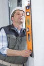 mature male contractor using spirit level Royalty Free Stock Photo