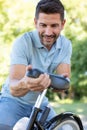 mature male cyclist adjusting bicycle seat