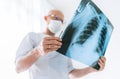 Mature Male doctor examining the patient chest x-ray film lungs scan at radiology department in hospital. Scan close up. Covid-19 Royalty Free Stock Photo