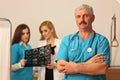 Mature male doctor with two female nurses Royalty Free Stock Photo