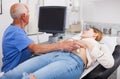 Elderly male sonographer examining woman