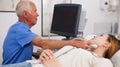 Elderly male sonographer examining woman