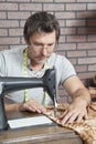 Mature male dressmaker stitching cloth on sewing machine Royalty Free Stock Photo