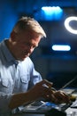 Mature Male Electronics Expert Repairing Laptop In Workshop With Low Key Lighting Royalty Free Stock Photo