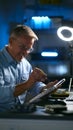 Mature Male Electronics Expert Repairing Laptop In Workshop With Low Key Lighting Royalty Free Stock Photo