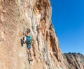 Mature male extreme Climber moving up on rocky Wall