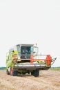 Mature male farmer driving harvester in field Royalty Free Stock Photo