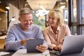 Mature Male And Female Business Colleagues Meeting Using Laptop And Digital Tablet In Modern Office Royalty Free Stock Photo