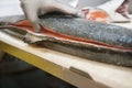 Mature male fishmonger cutting fish on table