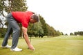 Mature Male Golfer Preparing To Hit Tee Shot Along Fairway With Driver