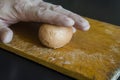 A mature male hand holds a boiled chicken egg in its shell against the chopping board Royalty Free Stock Photo