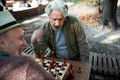 Mature male pensioner thinking about next move on chessboard Royalty Free Stock Photo