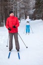 Mature male skier and woman stay on skis in winter snow skiing run