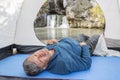 Mature male tourist sits in a tent and admires the beautiful waterfall atysh