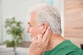 Mature man adjusting hearing aid Royalty Free Stock Photo