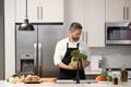 Mature man in apron choose ingredient. Home menu. Hispanic man cooking in kitchen. Healthy food for dinner. Man cooking Royalty Free Stock Photo