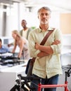 Mature man, arms crossed and bicycle in office with portrait and manager of sustainable company. Ceo, boss and job with