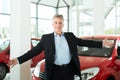 Mature man with auto in car dealership Royalty Free Stock Photo