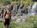 Mature man with backpack at waterfall pongour Royalty Free Stock Photo
