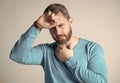 mature man with beard has heacache suffer from headahce on grey background, malaise