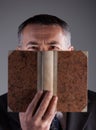 Mature man behind an ancient book Royalty Free Stock Photo