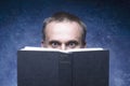 Mature man being focused and hooked by book, reading open book, surprised young man, amazing eyes looking blank cover, back to sch