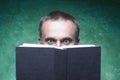 Mature man being focused and hooked by book, reading open book, surprised young man, amazing eyes looking blank cover, green