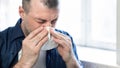 Mature Man Blowing Nose In Paper Tissue Sitting At Home Royalty Free Stock Photo