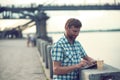 Mature man browsing on digital tablet in summer, on the river quay