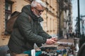 Mature man buys rare collectibles at a flea market. Nostalgia for the past