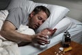 Mature man cannot fall asleep thus preparing to take medicine Royalty Free Stock Photo