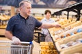 mature man choosing bread and baking in grocery section of supermarket Royalty Free Stock Photo