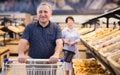 mature man choosing bread and baking in grocery section of supermarket Royalty Free Stock Photo