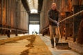 Mature Man Cleaning Cow Shed at Farm Royalty Free Stock Photo