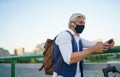 Mature man commuter with face mask and electric scooter outdoors in city, coronavirus concept. Royalty Free Stock Photo