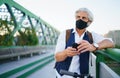 Mature man commuter with face mask and electric scooter outdoors in city, coronavirus concept. Royalty Free Stock Photo