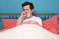 Mature man coughing because of flu sitting alone in the bed Royalty Free Stock Photo