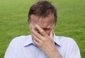 Mature man crying with hand partially covering his face