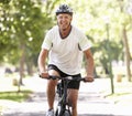 Mature Man Cycling Through Park Royalty Free Stock Photo